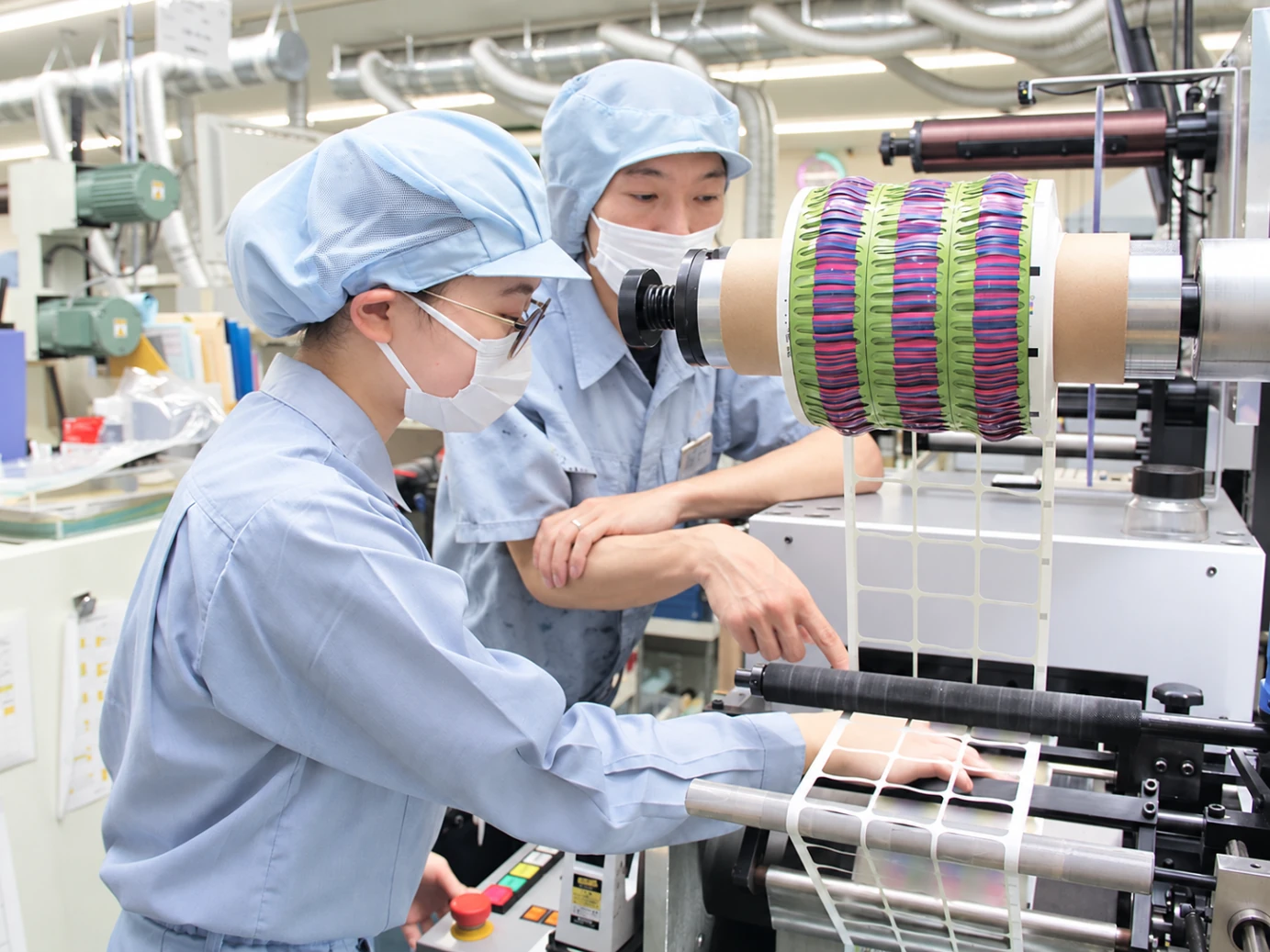 印刷機の前で、作業を一緒に確認する越後札紙の社員