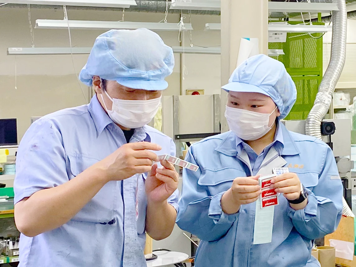 二人でシール・ラベルを手に取り、製品を確認する社員