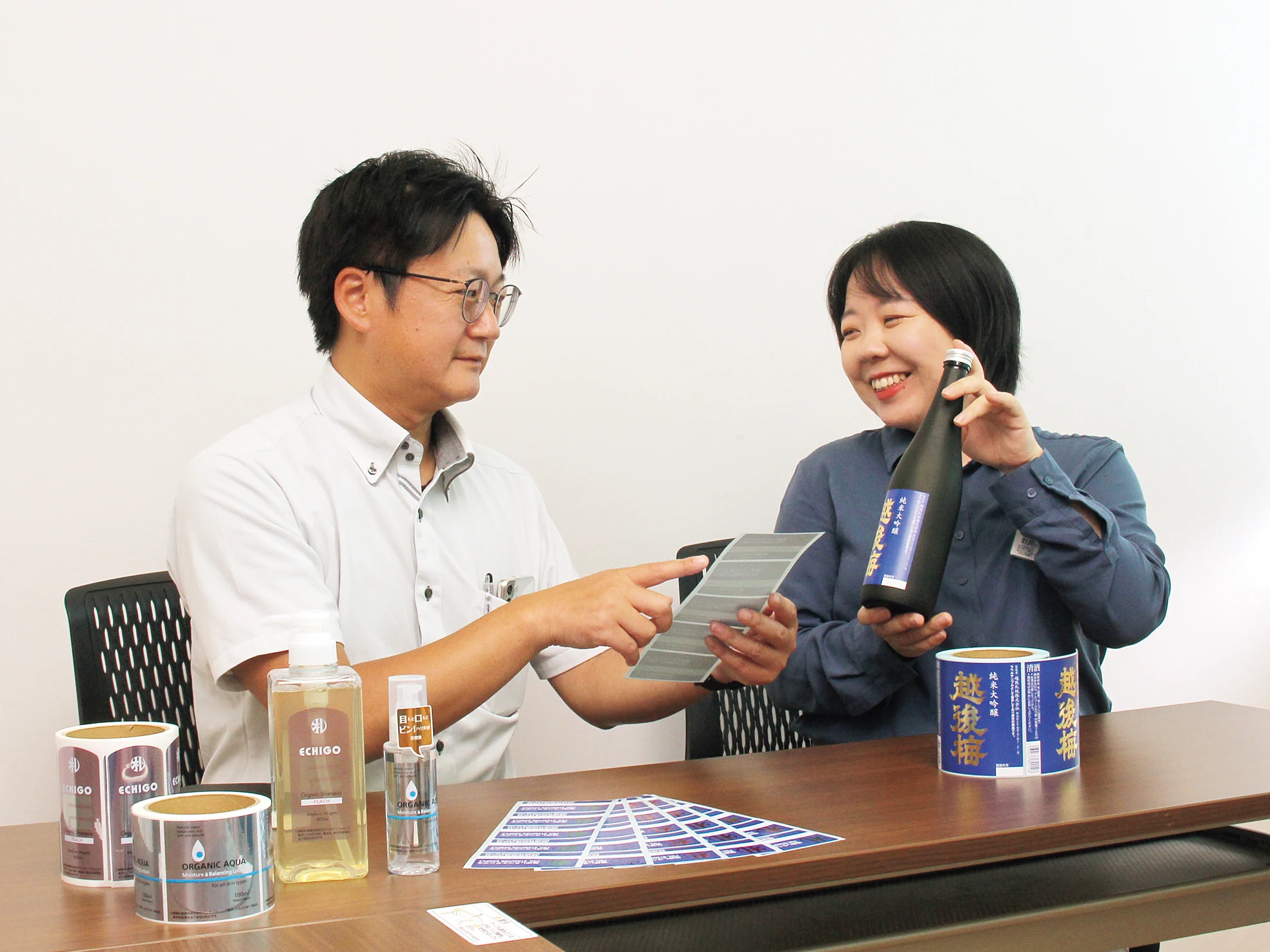 製品とシール・ラベルを見ながら相談する社員