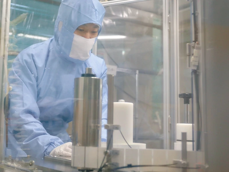 クリーンルーム内の機械を操作する社員
