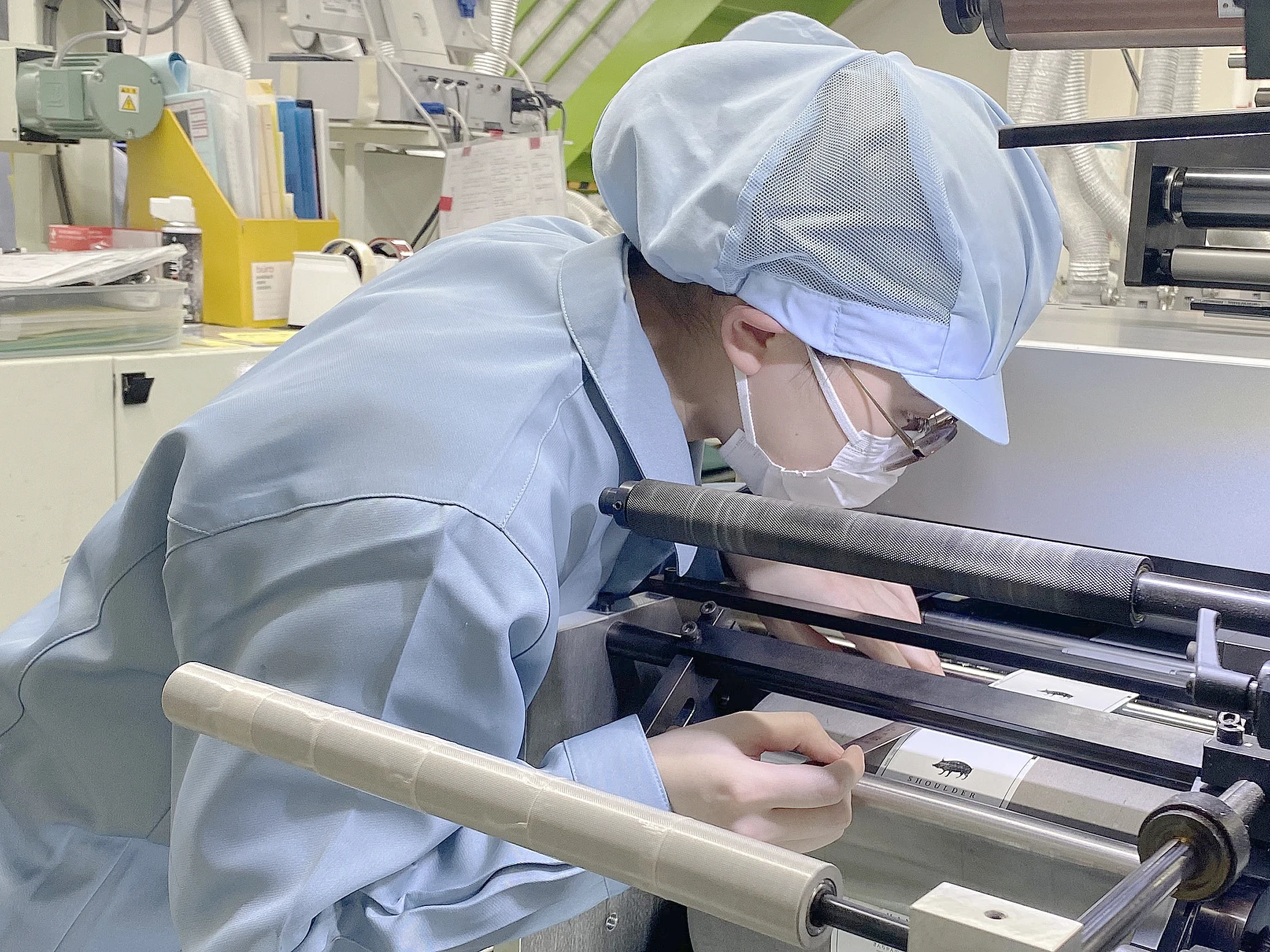 印刷機で仕上がりを確認する社員